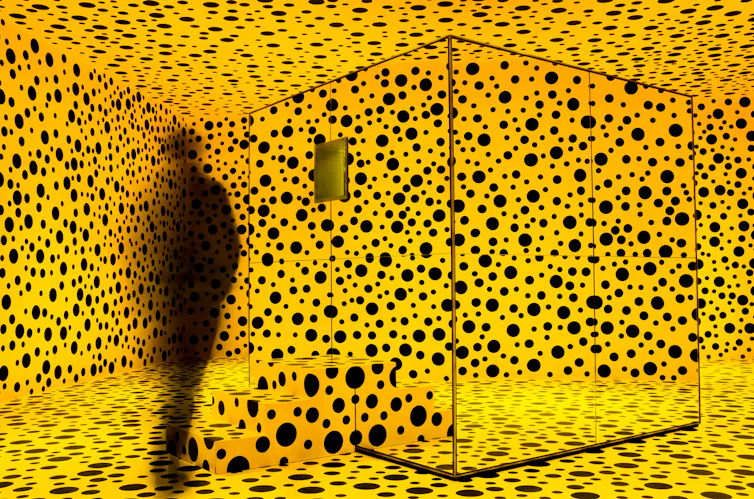 Una habitación completamente pintada en amarillo con lunares negros.