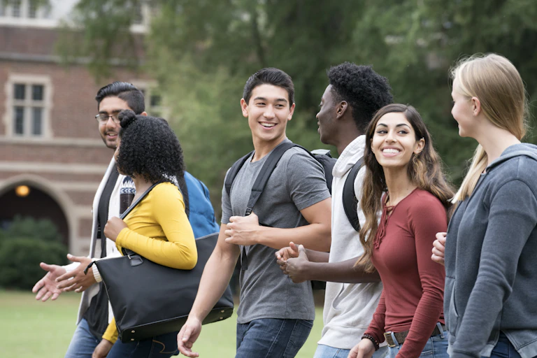 Six college students walk and talk on campus.