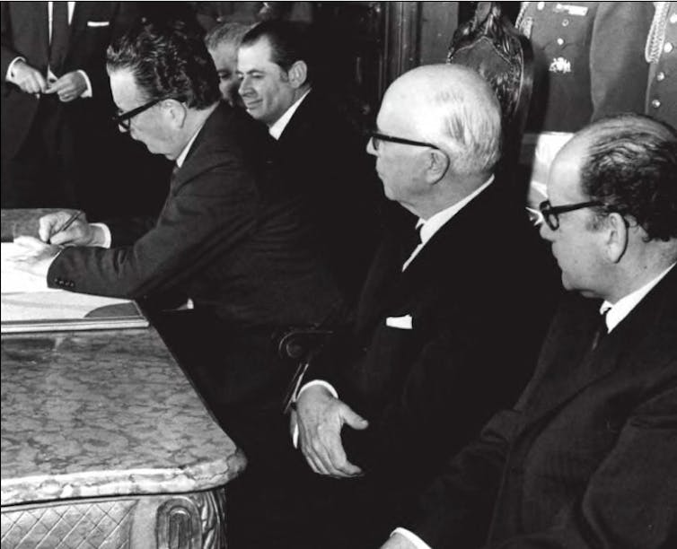 Salvador Allende firma un documento.