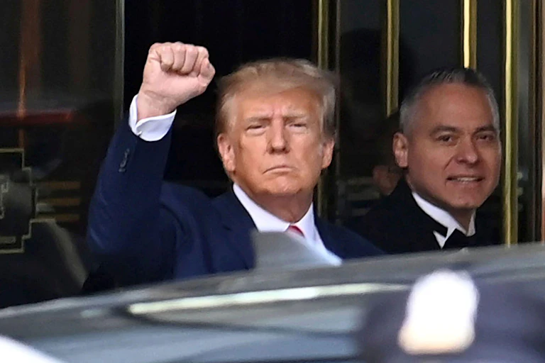 Former US president Donald Trump outside a New York court in September 2023 with his arm raised.