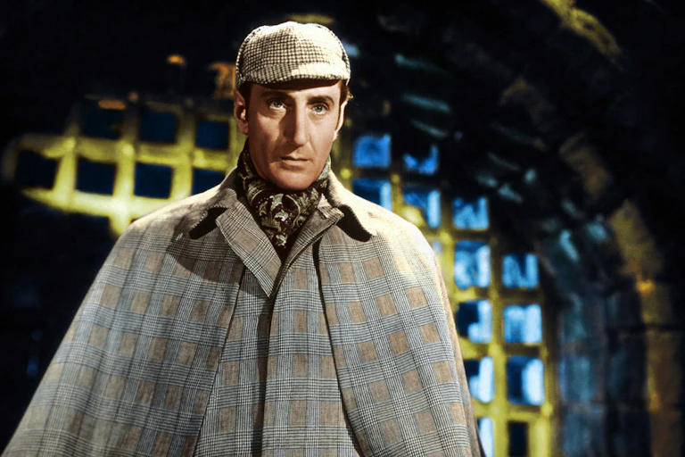 Sherlock Holmes in his signature deer stalker hat and cloak.