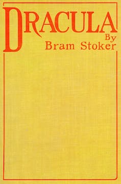 a yellow book jacket with the words 'Dracula, by Bram Stoker' in red.
