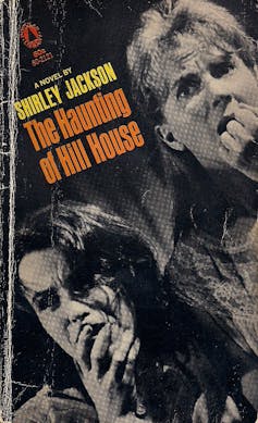 Two women cover mouths in fright on the book cover for The Haunting of Hill House.