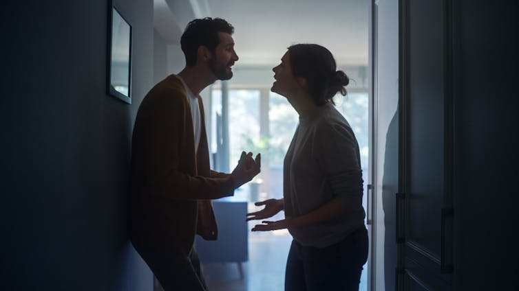 A man and woman in a kitchen arguing.