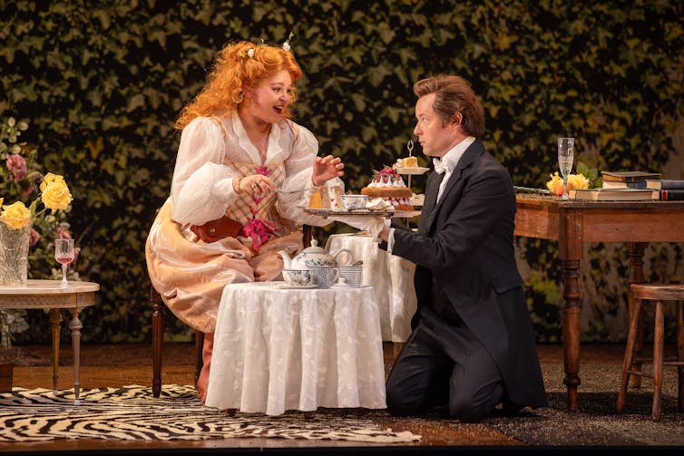 Production image: a young woman is served high tea.