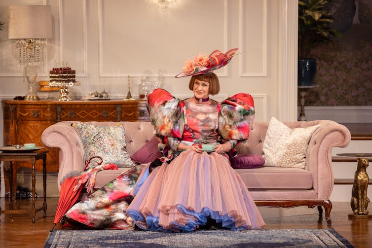 Production image: Helen Thomson in a pink dress.