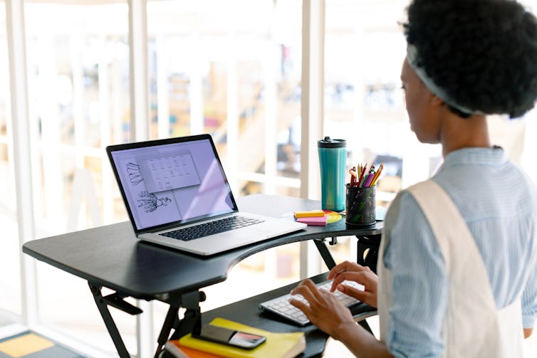 Woman stands at desk