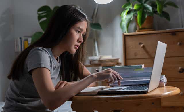 Mujer joven asiática trabaja en un ordenador portátil.