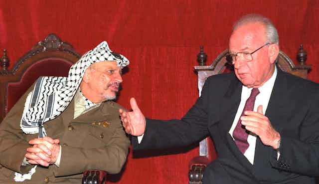 PLO chief Yassir Arafat leans in as Israeli prime minister Yitshak Rabin gestures