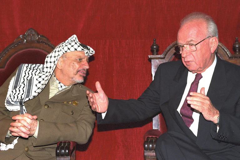 PLO chief Yassir Arafat leans in as Israeli prime minister Yitshak Rabin gestures