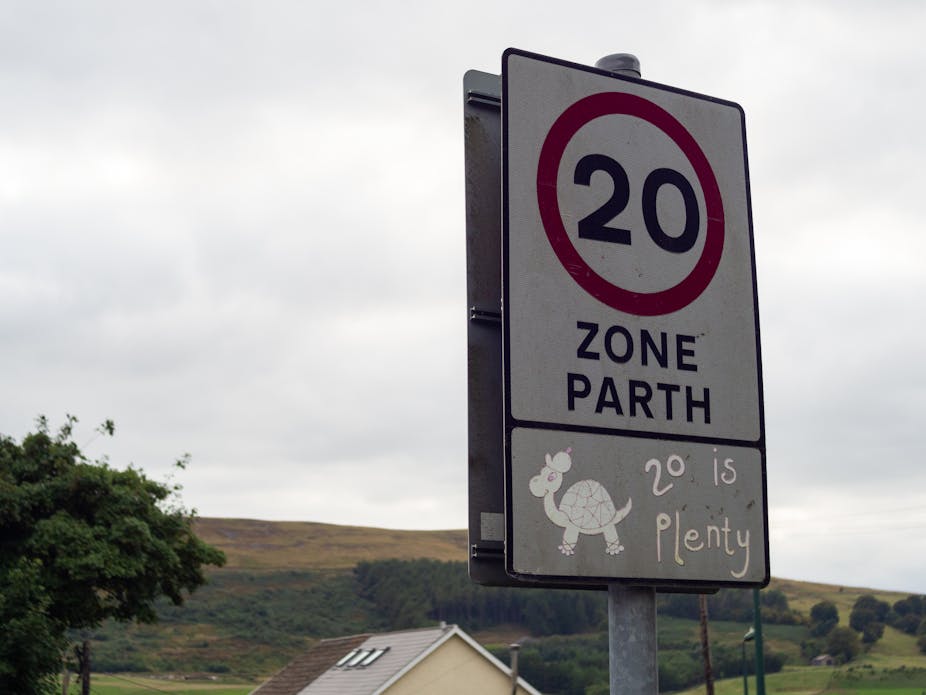 A bilingual 20mph road sign in Welsh and English.