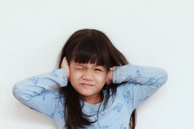 Girl holding her ears