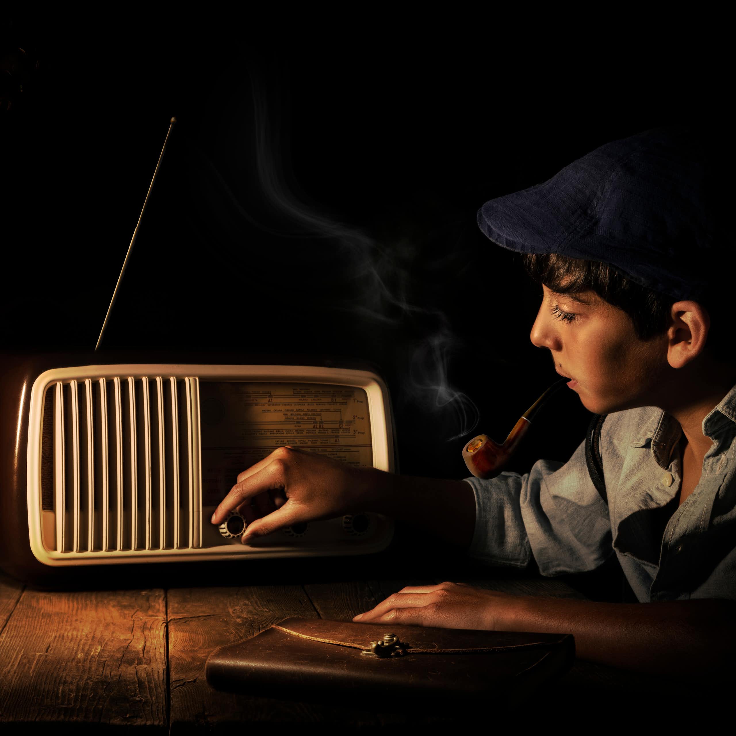 Anak laki-laki menyesuaikan radio kuno