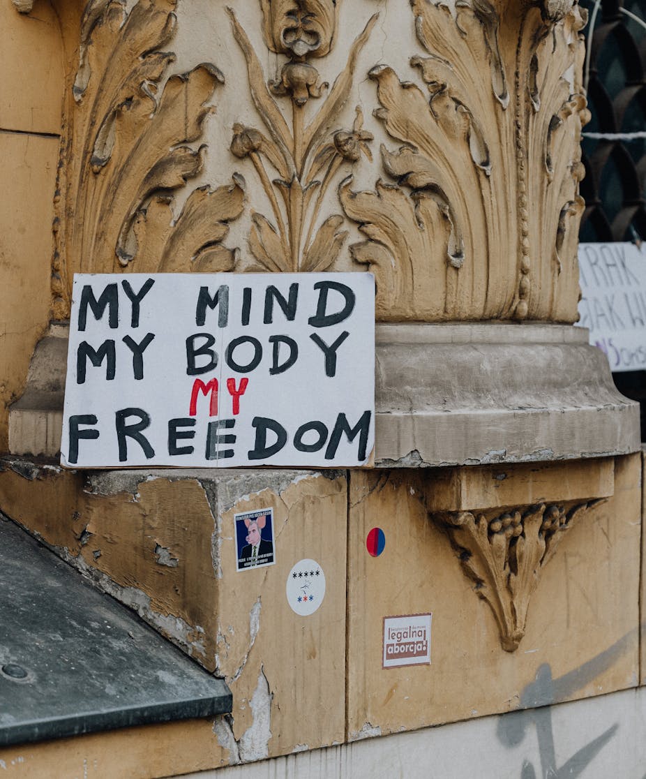 Sign saying 'my mind, my body, my freedom' propped up against wall.