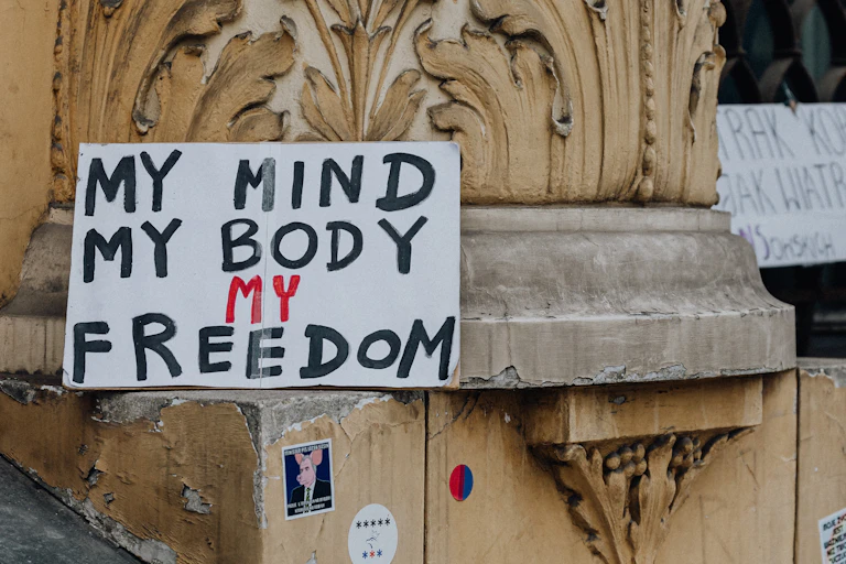 Sign saying 'my mind, my body, my freedom' propped up against wall.