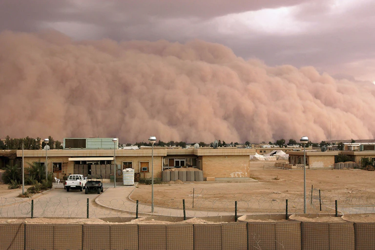 A wall of clouds towers above low-lying buildings