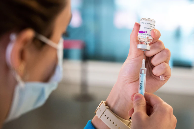 A nurse preparing a syringe with AstraZeneca vaccine against COVID
