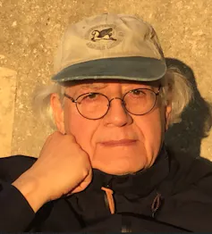 An older man in a baseball cap, Chilean documentary filmmaker Patrizio Guzmán, looking directly at the camera,