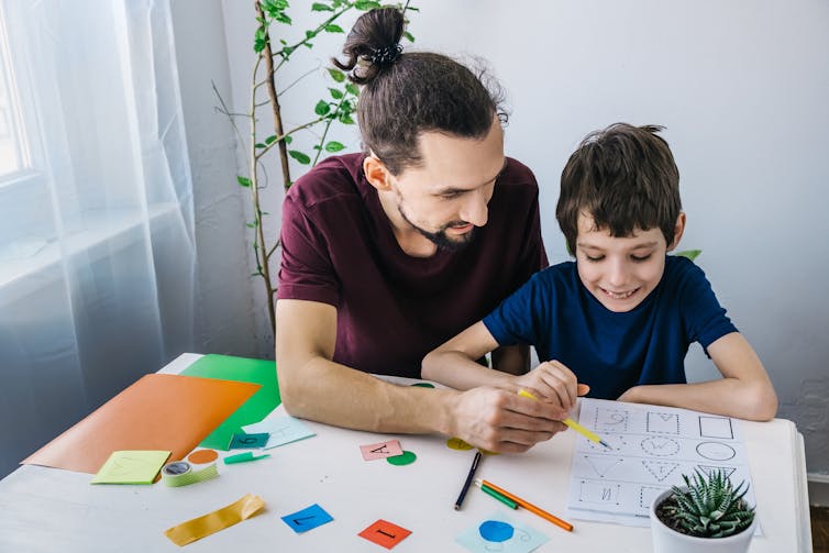 Man helps young child with a puzzle