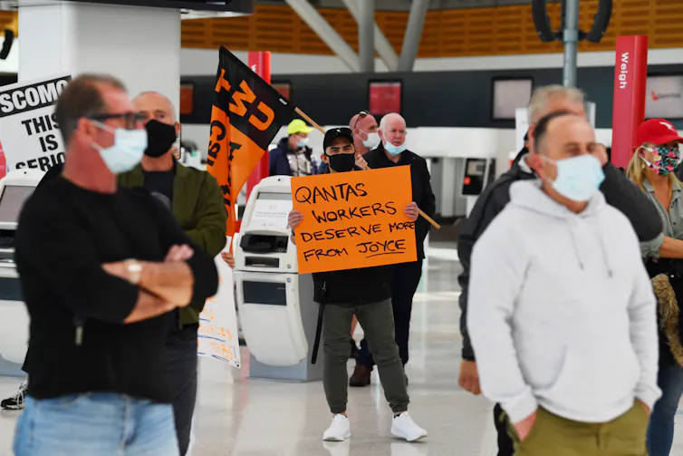 Striking workers waving placards at airport