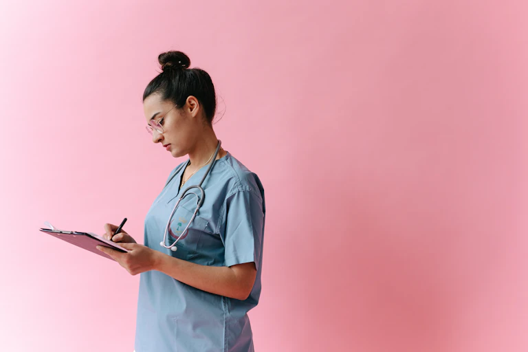 A nurse writes on a clipboard