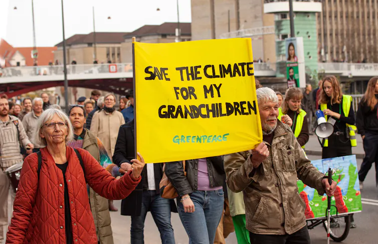 Grands-parents tenant une pancarte où l’on peut lire « Save the Climate for my Grandchildren » à Copenhague, Danemark le 30 octobre 2022