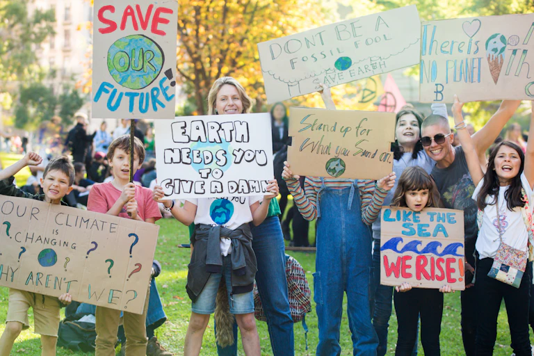 Des enfants entourés de leurs parents brandissent des pancartes où l'on peut lire des slogans s'insurgeant contre le dérèglement climatique