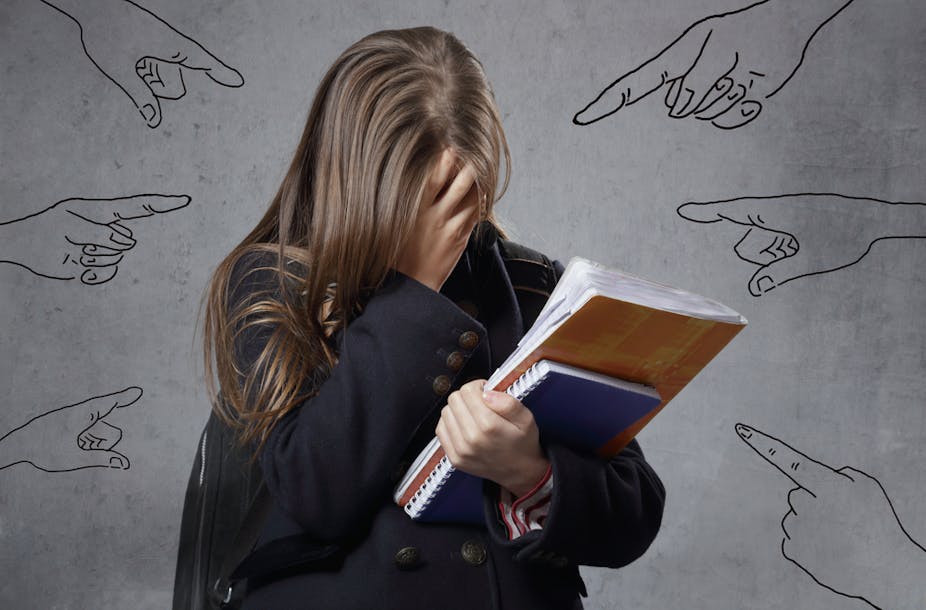 Adolescente solitaire en pleurs  avec des dessins de doigts pointés symbolisant le harcèlement