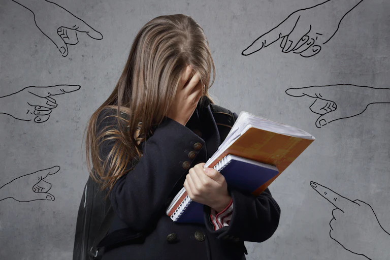 Adolescente solitaire en pleurs avec des dessins de doigts pointés symbolisant le harcèlement
