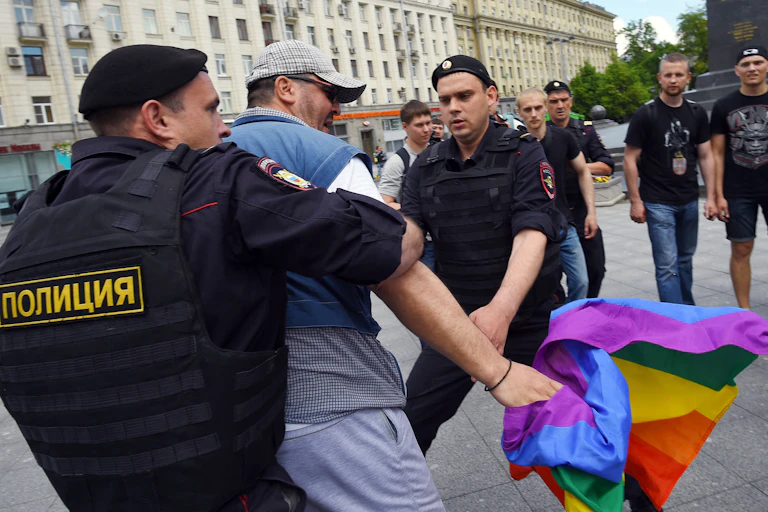 Des policiers russes arrêtent un homme tenant un drapeau aux couleurs de l'arc-en-ciel