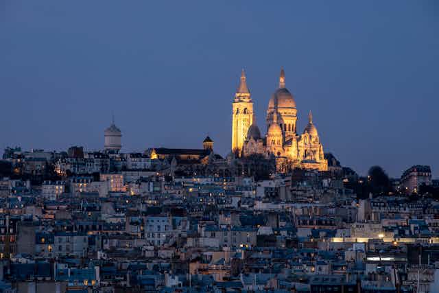 The Parisian skyline at night with Sacre Coeur lit up.