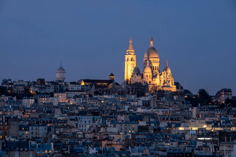The Parisian skyline at night with Sacre Coeur lit up.