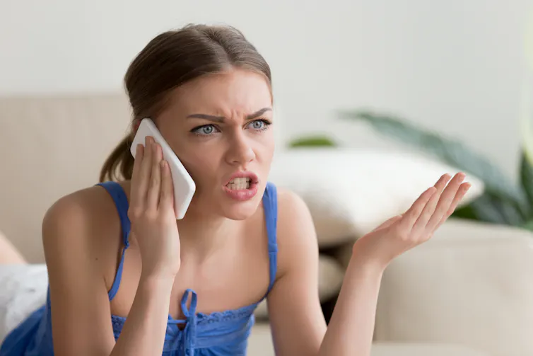 Women talking angrily into her phone will gesticulating.