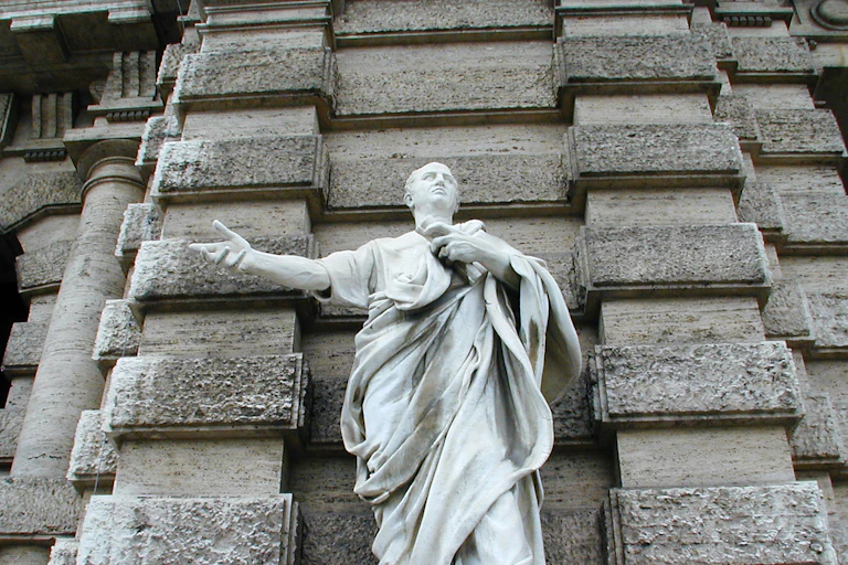 Statue of a classical figure against a wall.