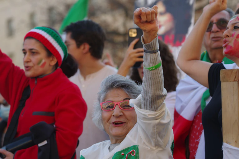 Women protesters raise their arms at a rally in Washington DC calling for change in Iran.