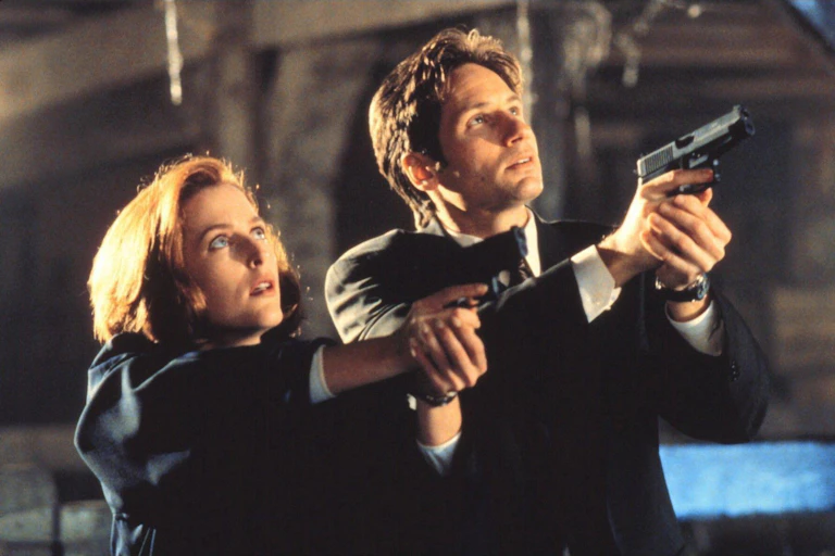 Gillian Anderson and Matt Smith in The X-Files, pointing guns at the sky.