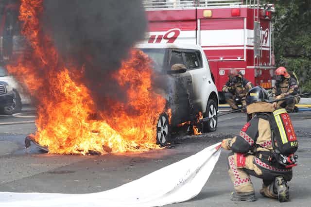 Firefighters are take part in a training drill to manage an electric vehicle