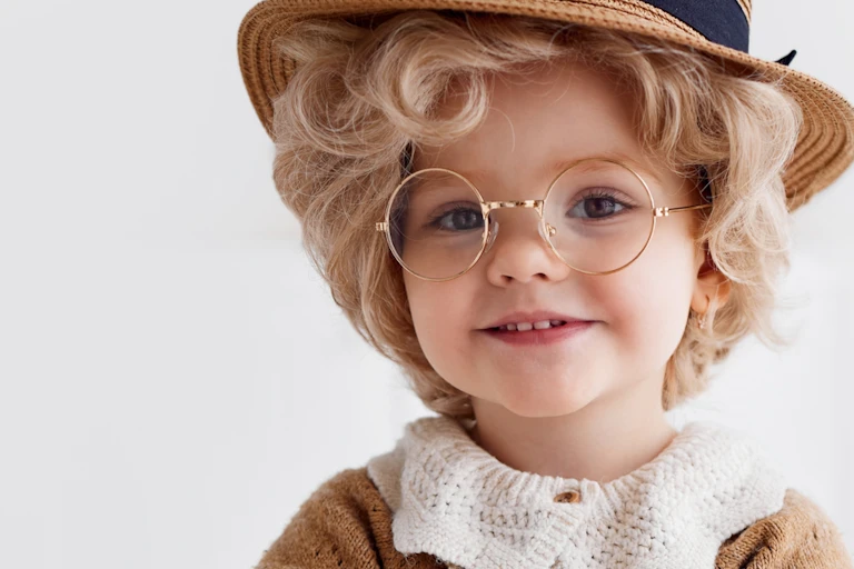 Young girl wearing hat and glasses, dressed up as old woman