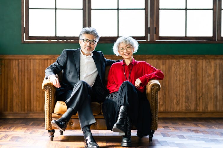 Older stylish couple sitting on sofa