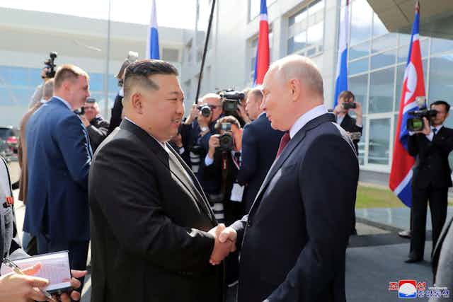 Russian president Vladimir Putin shakes hands with North Korean leader Kim Jong-Un.