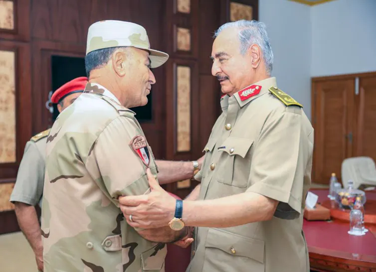 Libyan military commander Khalifa Haftar shakes hands with Egyptian military officer Osama Askar