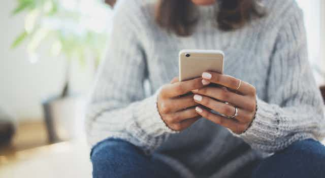 A woman holds a phone.