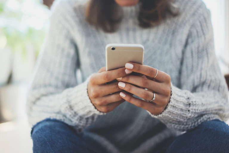 A woman holds a phone.