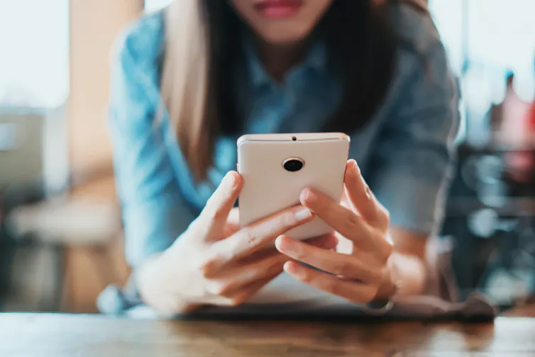 a woman looks at a phone.