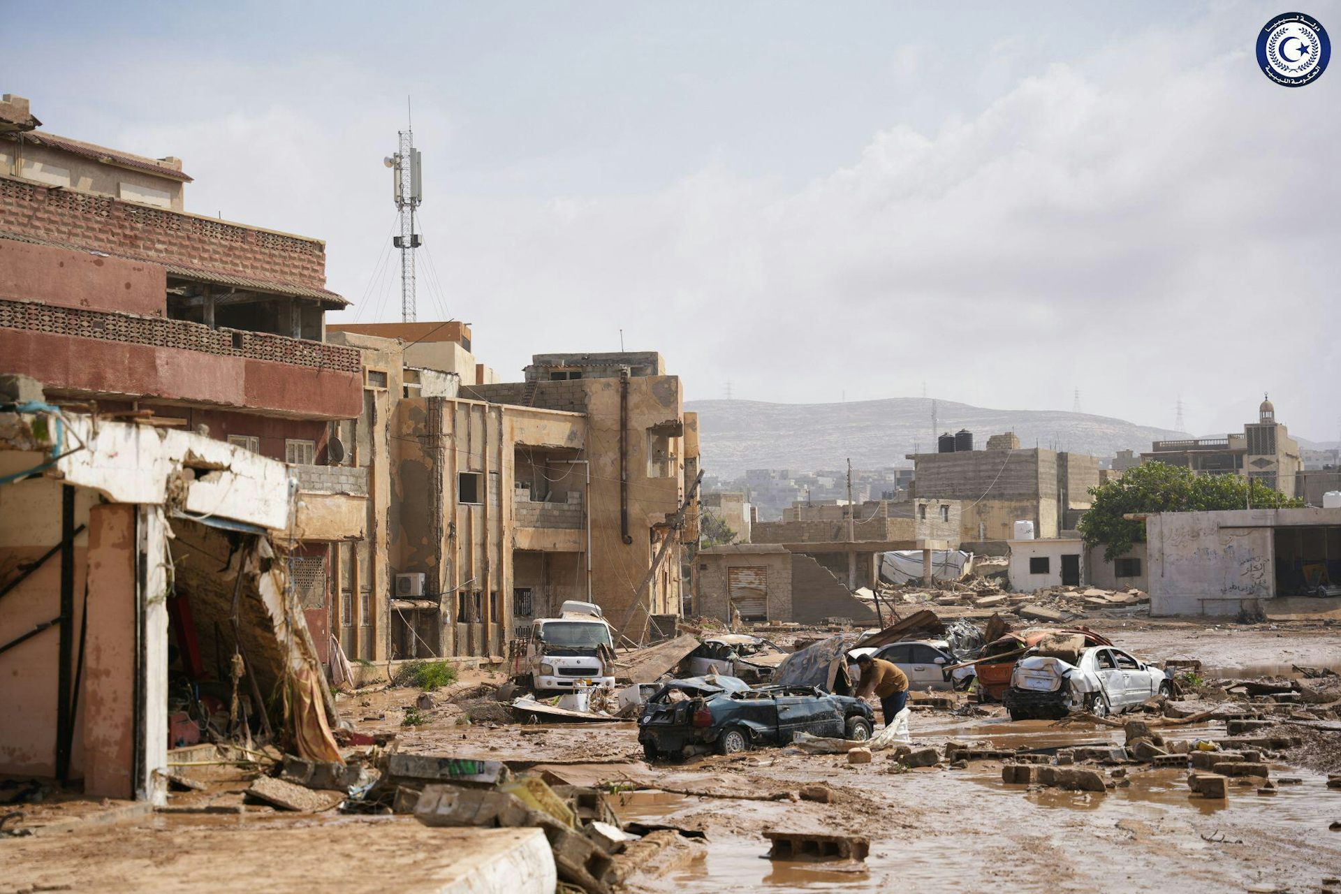 Damaged buildings, cars and floodwaters.