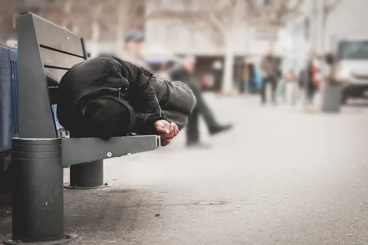 Un homme couché sur un banc