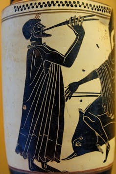 Un dibujo en cerámica muestra a un hombre tocando una especie de flauta de dos tubos.