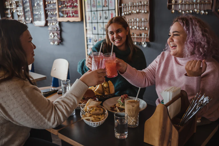 A group of people are having a meal together and smiling.