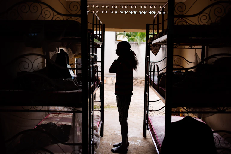 Person in silhouette against an open doorway between bunkbeds.