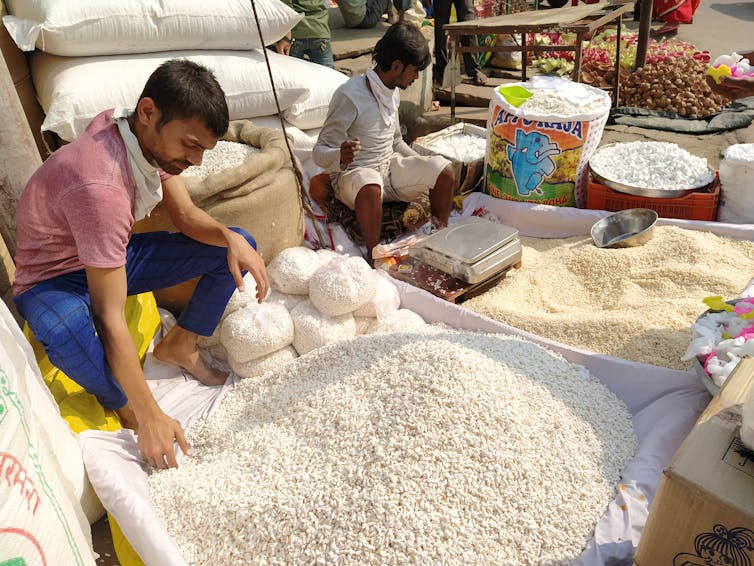 Un homme devant un étal de riz dans l’Uttar Pradesh en Inde